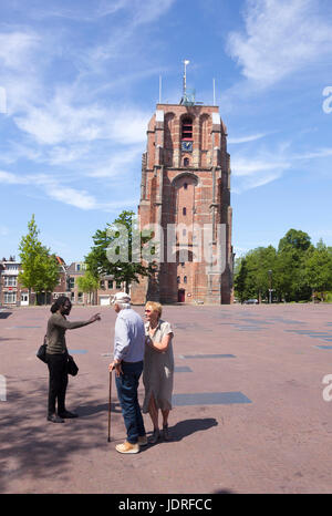 Leeuwarden, Netherlands, 11 june 2017: young black man talks to older couple near old lopsided tower oldehove in the center of ancient city Leeuwarden Stock Photo