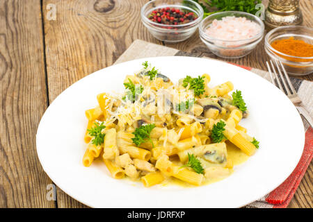Pasta with creamy cheese sauce and mushrooms on wooden background. Studio Photo Stock Photo