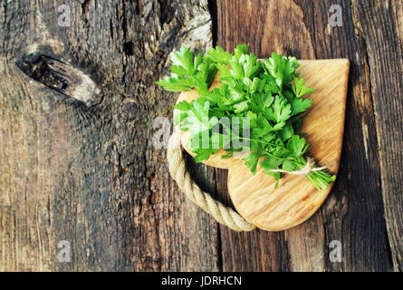 Fresh organic parsley on wooden cutting board. Macro with shallow dof Stock Photo