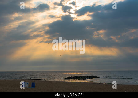 Rays of the morning sun break through the clouds on a summer morning Stock Photo