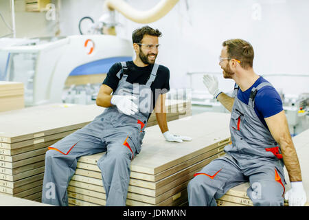 Two male workers working in furniture industry and creating custom furniture Stock Photo