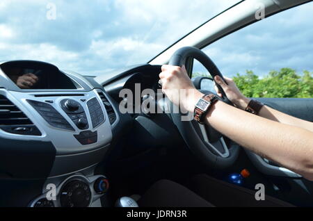 Woman's Hands on a Steering Wheel, Driving a Car on the Right Side Stock Photo