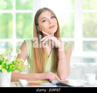 Portrait of a beautiful young woman reading magazine Stock Photo