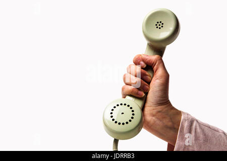 Hand holding a light green retro phone isolated on white background Stock Photo