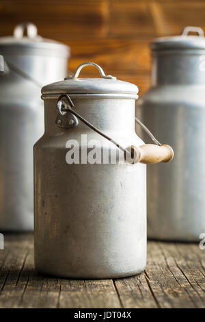 Aluminium milk can on old wooden table. Stock Photo