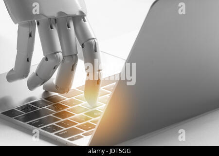 Artificial intelligence , robo advisor , chatbot , robotic concept. Robot finger point to laptop button with flare light effect. Stock Photo