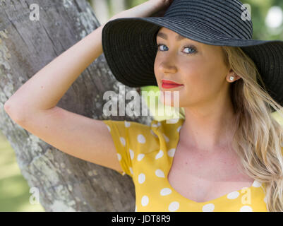 Young Australian woman in yellow polka dot dress relaxing at Palm Cove, near Cairns, Queensland, Australia Stock Photo