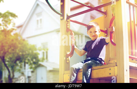 happy boy on children playground climbing frame Stock Photo