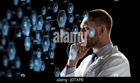 scientist looking at chemical formula projection Stock Photo