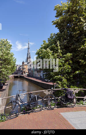 bicycles parked on bridge in centre of old town leeuwarden in friesland with boniface church in the background on sunny day early summer Stock Photo