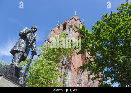 statue of troelstra next to oldehove tower in the centre of leeuwarden, capital of friesland, in the netherlands with blue sky Stock Photo