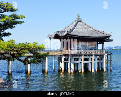A tree-canopied bridge leads to Ukimido Temple, on Lake Biwa, Otsu, Japan Stock Photo