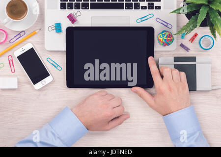 Office desk table workplace with digital tablet pc and mans hands on it top view flat lay Stock Photo