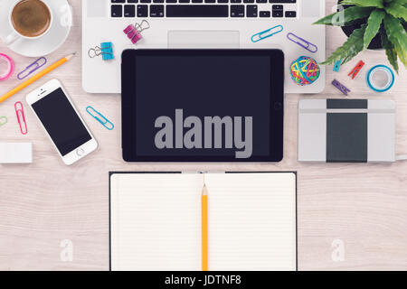 Office desk workplace top view with laptop tablet smartphone and open notepad with pencil Stock Photo