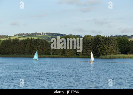 Boats sailing on Forfar Loch with a view of Balmashanner Monument in the background Stock Photo