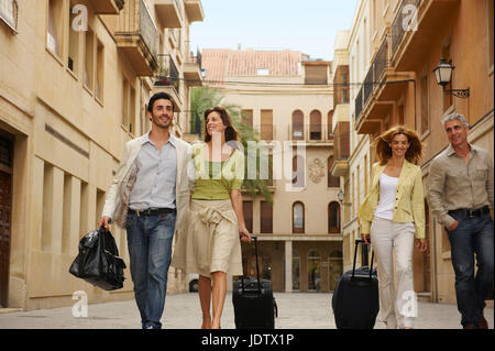 Two couples with cases walking Stock Photo