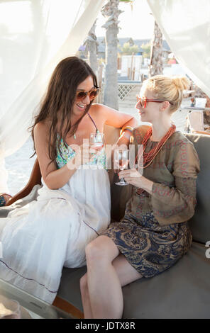 Two girlfriends enjoying glass of rose Stock Photo