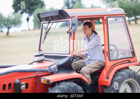 Female farmer driving a tractor Stock Photo