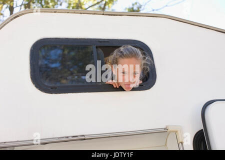 Girl peering out of RV Stock Photo