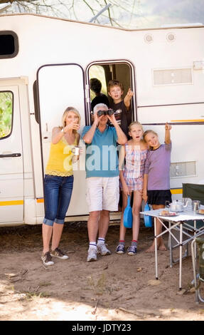 Family using binoculars at campsite Stock Photo