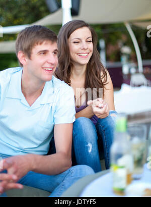 Smiling couple sitting together outdoors Stock Photo
