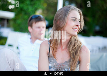 Smiling woman sitting outdoors Stock Photo