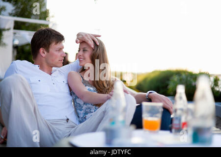 Couple relaxing on couch outdoors Stock Photo