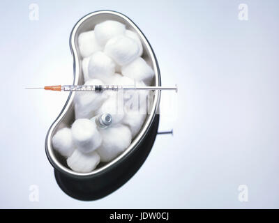 Cotton balls and syringe in kidney bowl Stock Photo