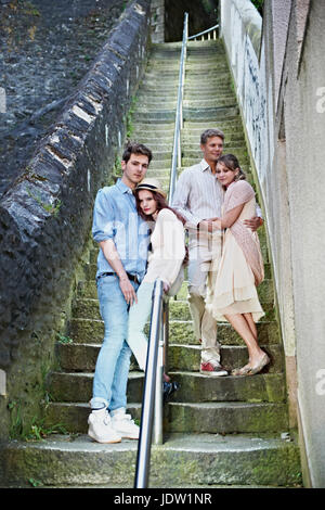 Friends standing on urban steps Stock Photo