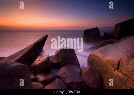 Blurred view of waves on rocky beach Stock Photo