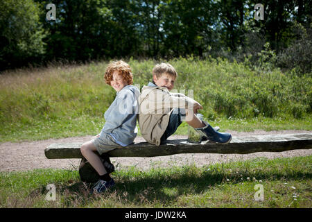 Children sitting on wooden bench Stock Photo