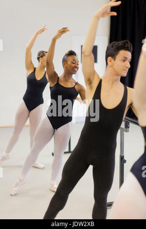 Ballet dancers practicing at barre Stock Photo