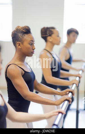 Ballet dancers practicing at barre Stock Photo