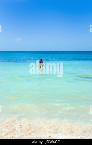 Woman in sea at beach in front of Dunn's River Falls, Jamaica Stock Photo