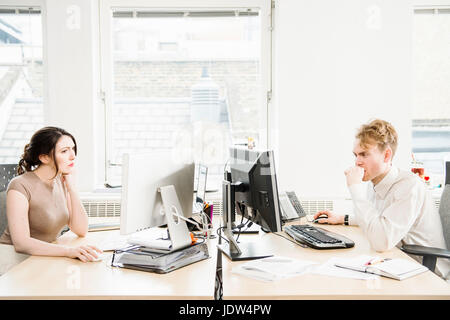 Two office workers using computers Stock Photo