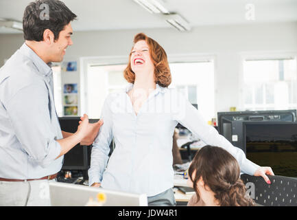 Colleagues laughing in office Stock Photo