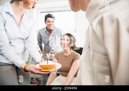 Female office worker receiving birthday cake Stock Photo