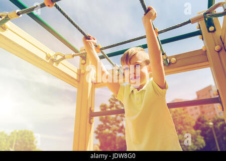 happy little boy climbing on children playground Stock Photo