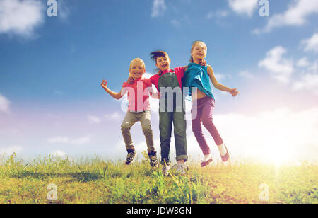 Group of kids jump high over blue sky and clouds, Stock image