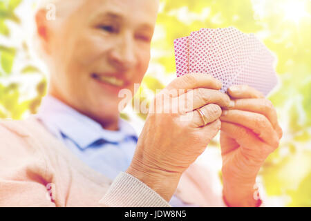 close up of happy senior woman playing cards Stock Photo