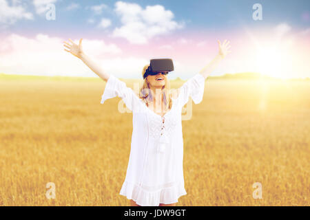 woman in virtual reality headset on cereal field Stock Photo