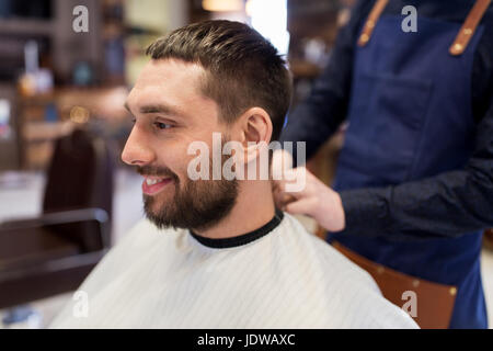 hairdresser and man with beard at barbershop Stock Photo