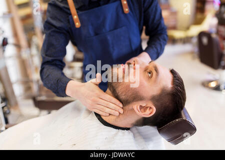 barber applying aftershave lotion to male neck Stock Photo