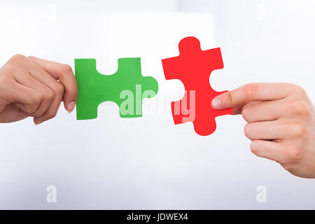 Cropped image of hands joining puzzle pieces Stock Photo
