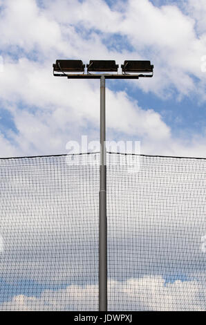 Lighting lanterns and protection grids in front of the blue sky with white clouds Stock Photo