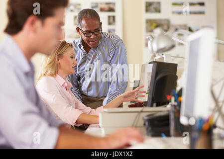 Workers At Desks In Busy Creative Office Stock Photo
