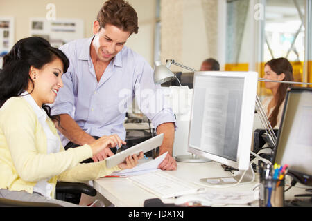 Workers Using Digital Tablet In Busy Creative Office Stock Photo