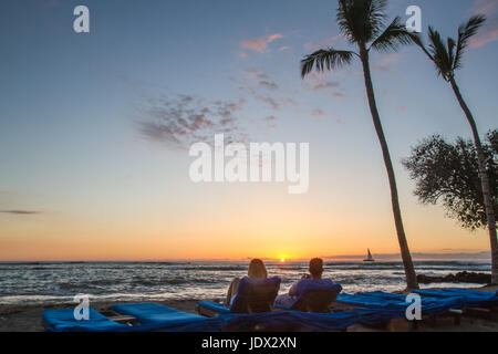 Couple enjoys Hawaiian sunset on beach Stock Photo