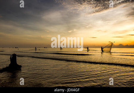 Sea clam digging fishermen golden sunrise Tan Thanh beach Go Cong Tien Giang Viet Nam Stock Photo