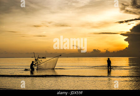 Sea clam digging fishermen golden sunrise Tan Thanh beach Go Cong Tien Giang Viet Nam Stock Photo